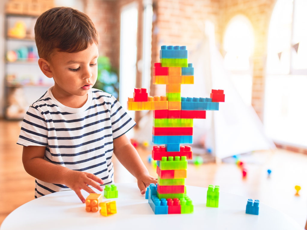 Toddler boy playing with construction blocks.