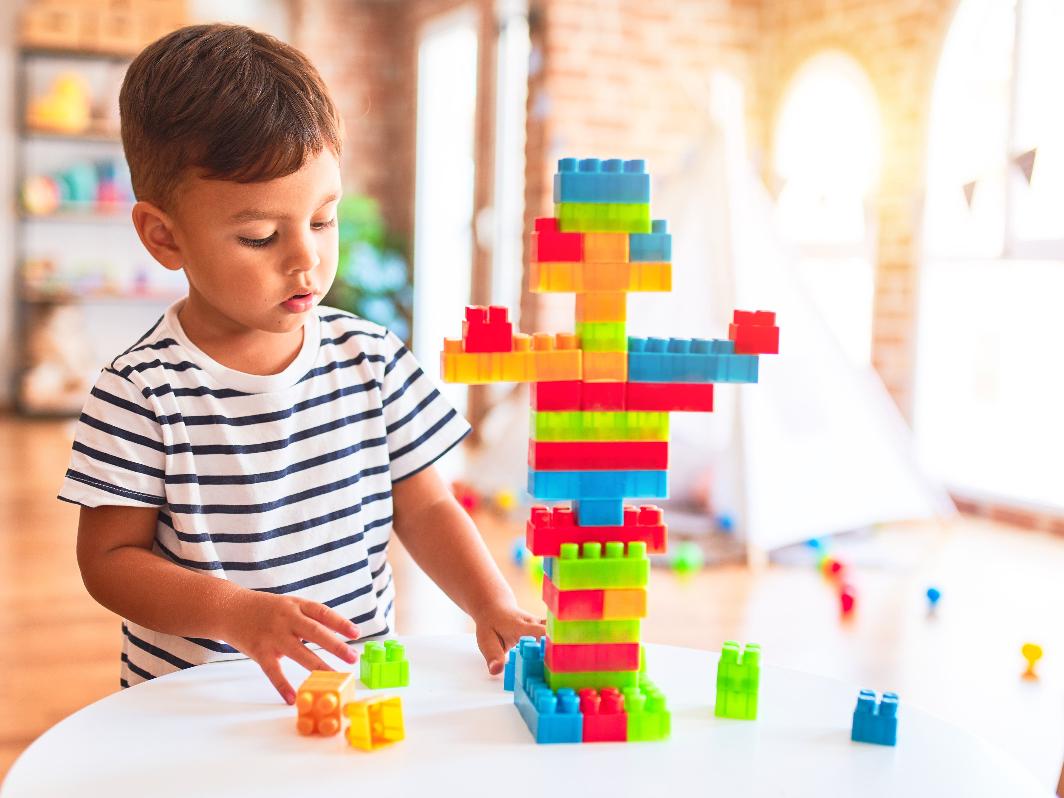Toddler boy playing with construction blocks.