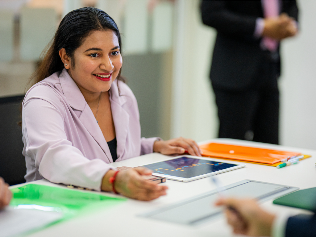 A woman sitting for a meeting with colleagues