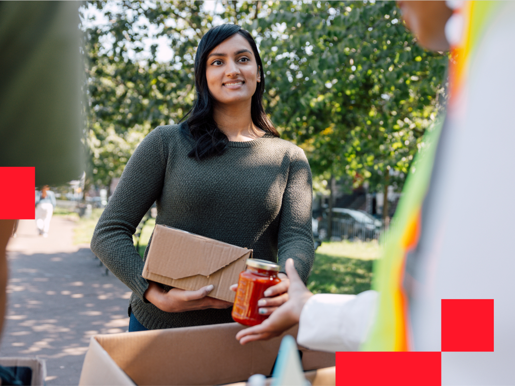 Volunteer giving a jar to a person.