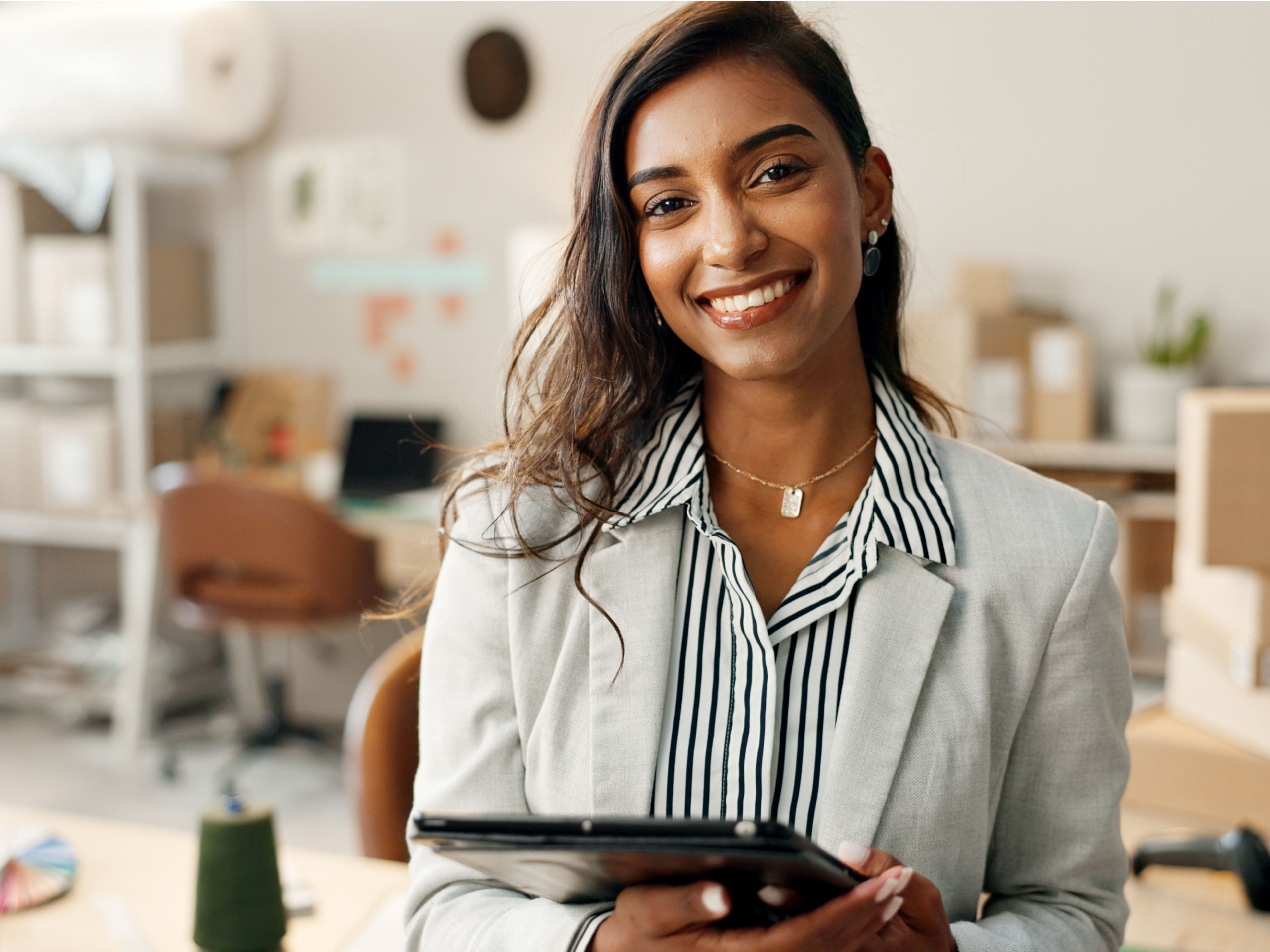 A lady is smiling in her office.